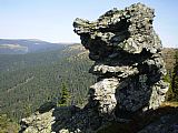 Dvě osamocené skalky pod vrcholem Břidličné, v té menší (na snímku) je malé skalní okno.