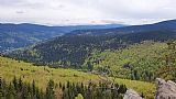 Výhled z Kamzičí skály na svazích Medvědího vrchu. Zprava lze rozeznat Praděd, Vysokou holi, Temnou a hřeben Lyry a Žárového vrchu.