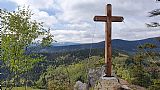 Kamzičí skála na svazích Medvědího vrchu s velkým dřevěným křížem.