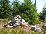 Kamenná mohyla a geodetický patník na vrcholu Stříbrnické.