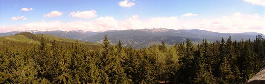 Panoráma Krkonoš z rozhledny na Předním Žalém. Zleva zasněžené tisícovky Lysá hora, Kotel, Harrachovy kameny, Vrbatovo návrší, před nimi již jarní Zadní Žalý a nezřetelné Šeřín, Černá skála a Mechovinec, v mracích Vysoké kolo a polský Smielec, za Medvědín