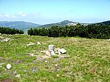 Geodetický bod na Krakonoši (spočinku Luční hory) na pozadí Malého Šišáku, vlevo Dívčí kameny a dvojitý vrchol Mužských kamenů.