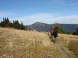 Ve vrcholových partiích Liščí hory se otevírá nádherné panoráma s výhledem na Sněžku.Turisté právě přicházejí.