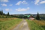 Chata Na Pláni pod vrcholem Přední Planiny v létě, za ní Zadní Planina, vlevo Luční hora a vpravo Světlý vrch.