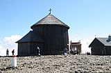 Vrchol Sněžky s rotundovou kaplí Sv. Vavřince, novou budovou poštovny a chatkou bývalého kiosku, v němž poštovna dosud úřaduje.