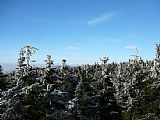 Výhled z posedu v sedle mezi Malou Deštnou a Velkou Deštnou. Na obzoru jsou nepříliš zřetelně vidět Krkonoše s nejvyšší Sněžkou.