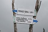 Polský turistický ukazatel na vrcholu Tabule udávající 45 min. doleva na hraniční přechod v Pomezních Boudách a 15 min. doprava na Soví sedlo.