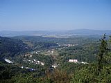 Výhled z rozhledny Bučina nad Kyselkou na okraji Doupovských hor na hřeben Krušných hor, z něhož vystupují uprostřed Božídarský Špičák a nejvýraznější Klínovec vpravo.