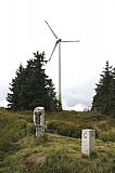Současná situace historického hraničního kamene na Klínovci. Vedle je soudobý kámen s číslem 14, jsou dosud patrné příkopy z 19. století a v pozadí větrná elektrárna nad Neklidem.
