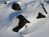 Tyto podivně černé kameny na vrcholové plošině tisícovky Nad Rýžovnou nejsou žádnou geologickou zvláštností, ale pozůstatkem po těžbě dřeva a vypalování větví.