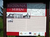 Informační panel o téměř zaniklé obci Rýžovna leží mezi tisícovkami Nad Rýžovnou a Nad Rýžovnou - JZ vrchol.