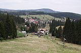 Pohled ze SV svahu Perninského vrchu. Lyžařská sjezdovka, Pernink a na obzoru Plešivec s rozhlednou.