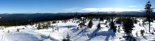 Zimní panorama z Oblíku od východu k jihu. Zleva Huťská hora s dobře patrnou zasněženou prolukou osady Zhůří a Břemenem, s nediferencovatelným vrcholem Jeleního kaliště, více vpravo dominuje Antýgl / Sokol, Březová hora a Tetřev, mezi nimi v dáli Boubínsk