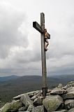 Na kříži na vrcholu Luzného byla obnovena socha Krista. V pozadí Špičník, Blatný vrch a vlevo ostrý vrchol Roklanu.