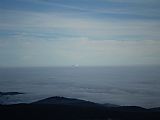 Pohled z vrcholu Boubína na východ. Jednotvárné bílé moře z inverze narušuje pouze horký vzduch z chladících věží Jaderné elektrárny Temelín.