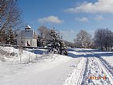 Pohled od Kříže smíření ve Zhůří pod Hadím vrchem ke kapli Nejsvětější trojice.