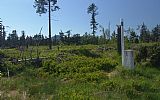 Hraniční mezník 18/9 na vrcholové plošině Helmwaldu. Vpravo od smrku vystupuje Ostrý.