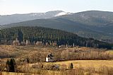 Pohled od hotelu Zach v Zelené Lhotě na Ostrý a vrchol Na výšině. V popředí je kostel Sv. Wolfganga.