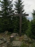 Vrcholový kříž a geodetický bod na malé skalce na Poledníku.