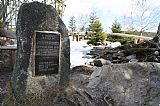 Pomník studenta Ottokara Kareise a lavičky pro turisty na břehu Prášilského jezera pod Poledníkem a Skalkou.