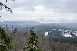 Výhledy od Stožecké skály (974 m) ležící na J úpatí Stožce. V levé části jsou patrné vrcholky obou šumavských Hvozdů a Jelenské hory.