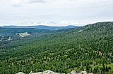 Výhled z Bavorského Luzného (1 373 m) na protější Velkou Mokrůvku. Pod kopci, na úpatí Studené hory hájovna Březník. Na horizontu Poledník s rozhlednou.