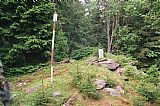 Geodetický bod a historický patník na skalnatém spočinku v blízkosti vrcholu Větřína.
